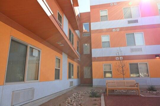 The development features an enclosed courtyard with a barbecue grill, patio seating and green space, as well as a large garden.